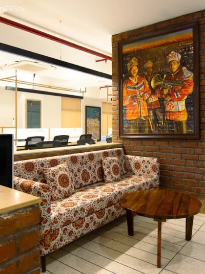 A cozy breakout nook at the Harappa Office, featuring a patterned sofa against an exposed brick wall. This project highlights my general contracting work in executing designs with rich textures and cultural art pieces.