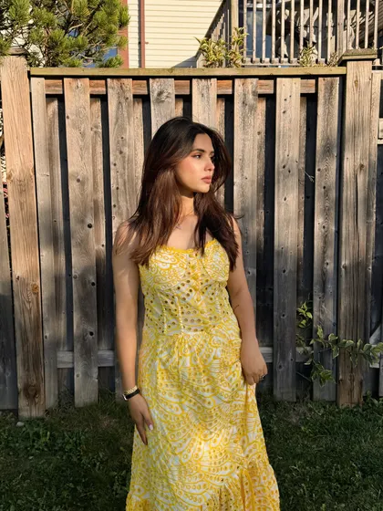 Another angle of the yellow summer dress from Jardinvue, highlighting its delicate pattern.
