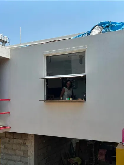 (Duplicate of 45) The large pivot window in the studio creates a serving hatch-like opening, connecting the interior workspace with the outdoor environment.