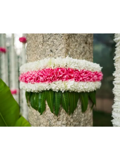 A detail shot of the floral and leaf decorations on the pillars, adding a touch of natural beauty to the entrance.