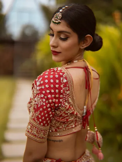 A view of the beautiful back details of the blouse and the elegant bridal bun. Every detail is considered for the perfect wedding day look.