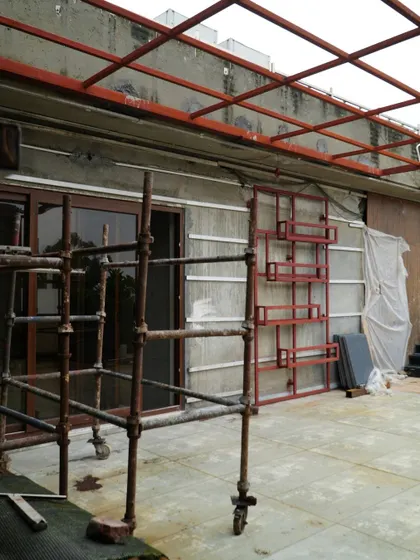 The initial setup for a feature wall on the Pitampura terrace. The metal frame for the planter rack is in place against the wall, ready for the next stage of installation.