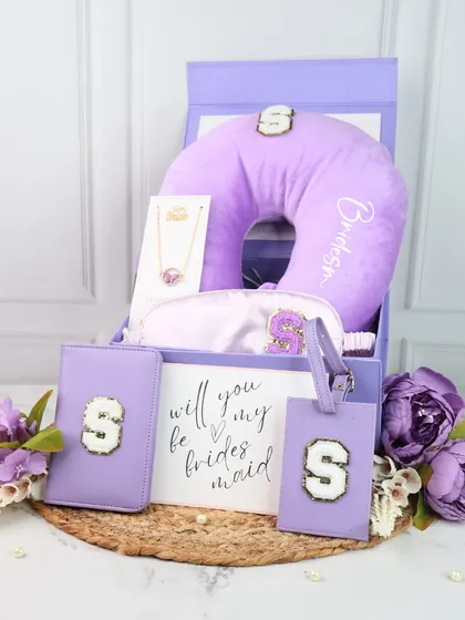 For a touch of modern elegance, I designed this bridesmaid travel hamper in a lovely lilac shade. The gift box includes a personalized neck pillow, eye mask, passport cover, and luggage tag, all featuring a custom initial.