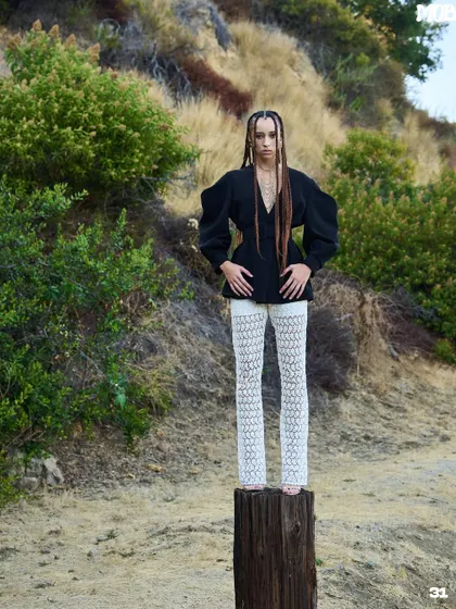 A striking shot from the MOB Journal LA editorial, with the model posed on a wooden post against a natural backdrop.