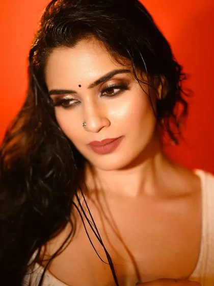 A moody close-up with wet hair and an intense look. The red background enhances the dramatic feel of the portrait.