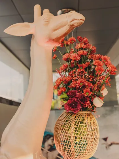 A close-up of the giraffe holding a custom-made basket of flowers, a whimsical detail that guests loved.
