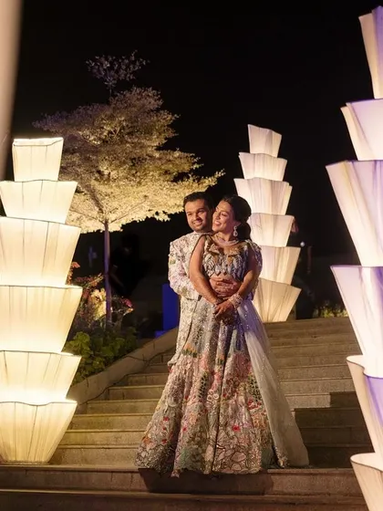 The couple poses for a photo amidst the dramatic light installations.
