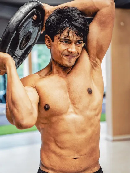 Staying in your comfort zone is the biggest risk. Here I am doing a plate halo, an exercise that builds shoulder stability and core strength, pushing past the easy path.