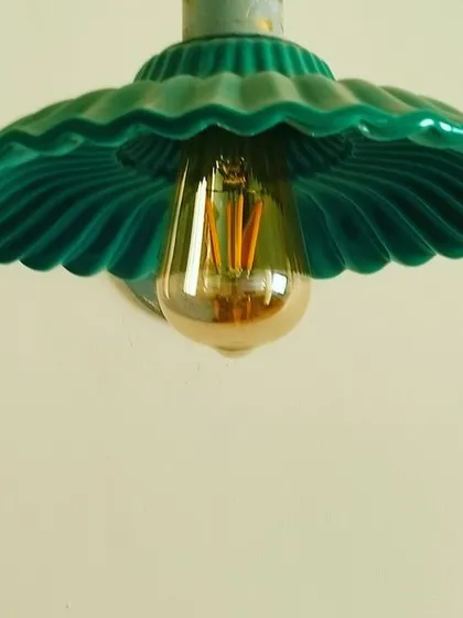 Designer lamps can add a pop of color and personality. This vintage-inspired green pendant light with a fluted shade is a perfect example of a small detail that makes a big impact.