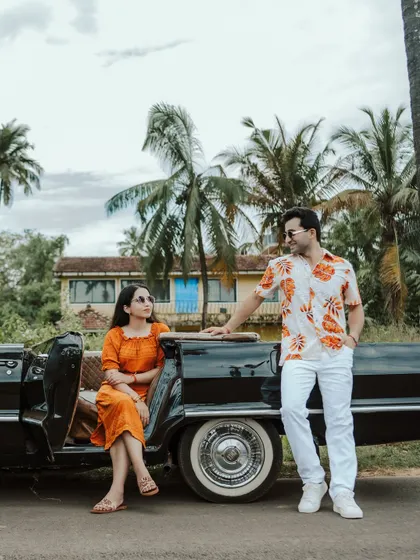 A stylish couple poses with a vintage Chevrolet convertible on a palm-lined road in Goa. This shot combines travel, style, and romance, perfect for a cinematic pre-wedding story with a cool, retro vibe.