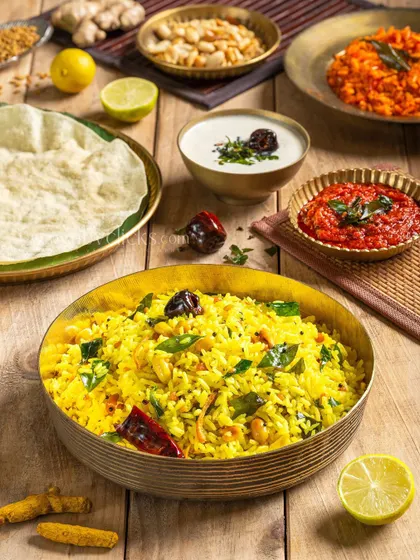 A bowl of vibrant Lemon Rice, a South Indian specialty, styled with curry leaves, dried red chilies, and other spices.