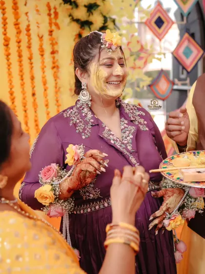 A candid moment of laughter and joy as the bride interacts with her family during the Haldi ritual.