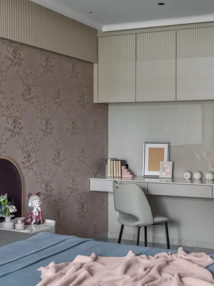 This bedroom uses beige as a base color, with pops of purple and pink to add charm. The streamlined study desk and overhead storage make it a cozy and functional space.