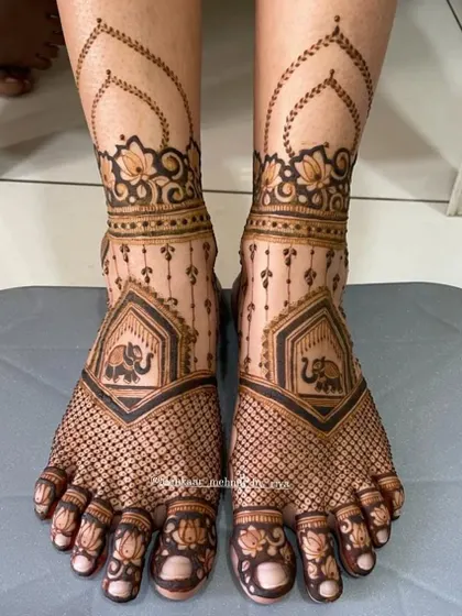 This delicate bridal feet design features a net pattern across the foot, with a small elephant motif and lotus details on the toes.
