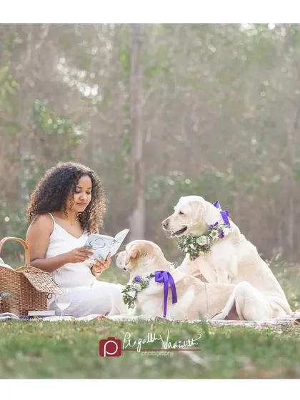 Story time in the park. This idyllic scene of a woman reading to her two attentive Labradors is like a moment out of a storybook.