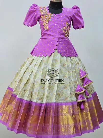 A Kanchi pattu lehenga with a unique, asymmetrically embroidered blouse. The gold floral embroidery on the purple top adds a modern and artistic touch.