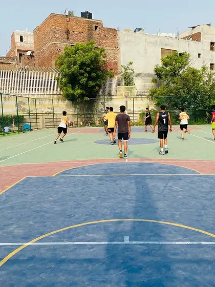 A wide view of a full-court practice game, showing players transitioning from defense to offense.