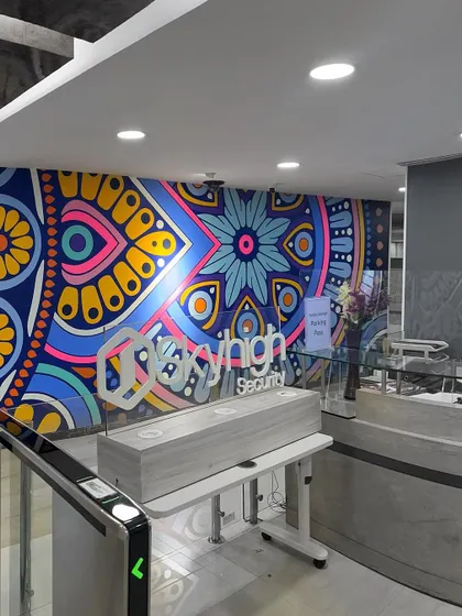 The entrance to Skyhigh Security, where our vibrant mandala mural welcomes everyone. The design incorporates the company's logo and brand colors into a complex, beautiful pattern.