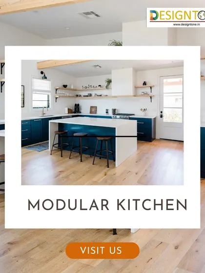 A spacious modular kitchen with an island, featuring dark blue cabinets and a white countertop. The design includes open shelving and ample natural light, creating a welcoming and functional cooking environment.