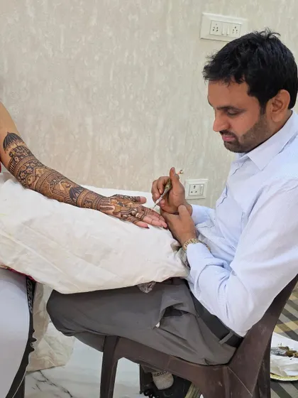 A close-up of me at work, carefully applying a detailed pattern. My full concentration is on the art, ensuring every part of the design is flawless.