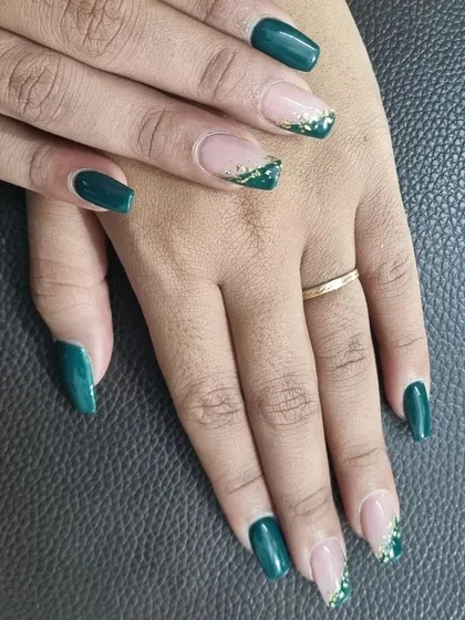A glamorous take on the French manicure. This design features deep green tips with a cascade of gold foil, creating a rich and festive look.