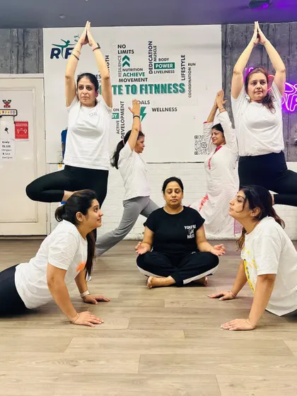 Finding balance and peace together. This photo captures a moment of collective focus, with members practicing a variety of poses from seated meditation to standing balances.