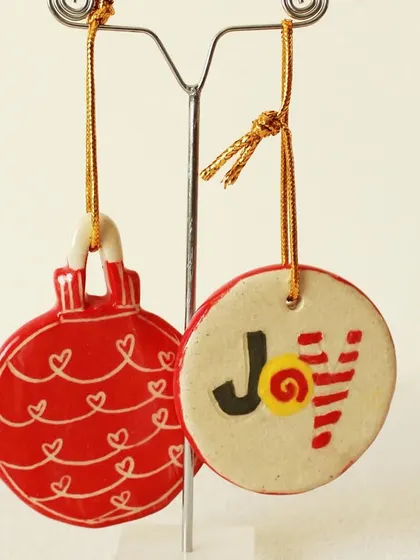 These flat, disc-shaped ornaments are hand-painted with joyful messages and patterns. They are lightweight and perfect for hanging on any tree.