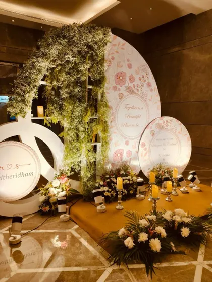 A personalized vow space, with custom-printed backdrops, a cascade of greenery, and the gentle glow of candles, creating a cozy and romantic nook for the couple.