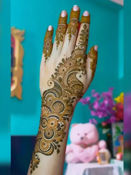 This graceful Arabic mehendi design flows from the wrist to the index finger. The combination of delicate leaves and bold, shaded patterns creates a very elegant look.
