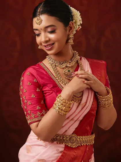 A candid pose showing the elegance of the full set, including the vaddanam and bangles.