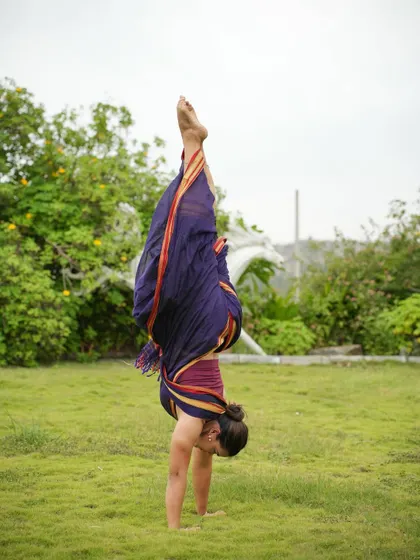 A handstand in a saree, breaking the stereotype that traditional wear is restrictive. A handstand requires total body integration, from the fingertips to the toes.