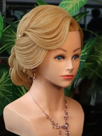 A front view of the rose bun hairstyle. Practicing on a mannequin helps you understand how to frame the face and place accessories for the most flattering look.