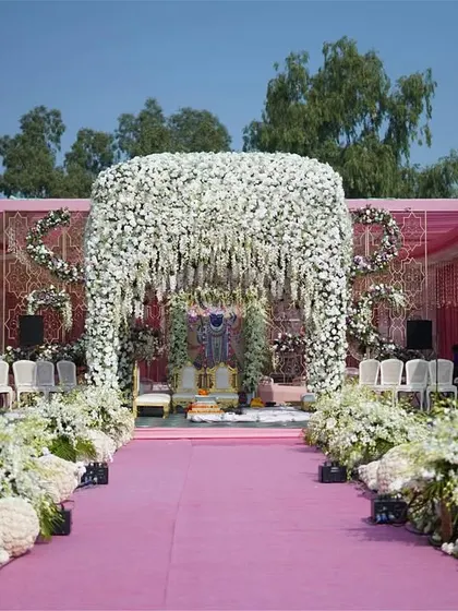 The full view of our ‘Ivory Paradise’ mandap, showing the grand floral structure, the lush aisle decor, and the elegant guest seating. This is how we create a cohesive and immersive wedding environment.