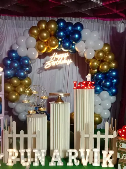 Here is another angle of Punarvik's first birthday party decor, showing the blue, gold, and white balloon arrangement. I can customize the color palette to perfectly match your party's theme.