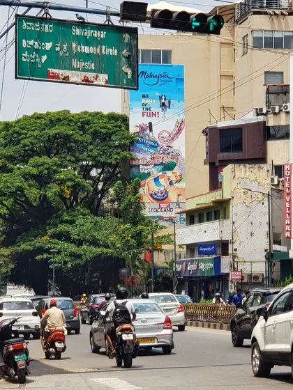 A view of the theme park mural from across the street, showing its impressive scale in the middle of city traffic.