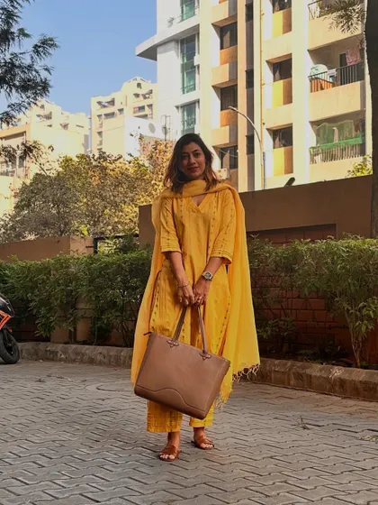 This yellow kurta set with a large tote bag represents a more classic and ethnic personal style. It's important to discover your own vibe instead of just chasing trends.