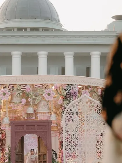 The groom's first look at his bride as she appears at the end of the aisle, with the palatial facade of Raffles Udaipur in the background. We choreograph these moments to be cinematic.