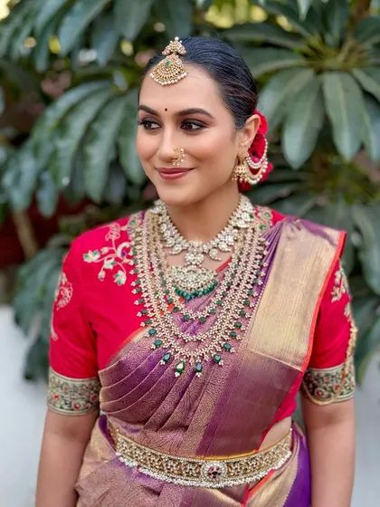 Divine goddess vibes for this stunning bride. The look features golden, kohl-rimmed eyes and dewy skin that glows with grace, perfectly complementing her layered diamond and emerald jewellery.