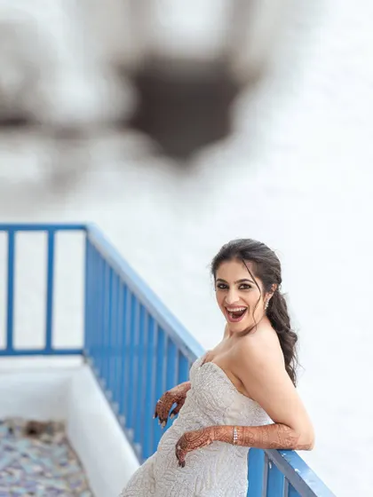 A joyful and spontaneous portrait of the bride on the balcony. Her exuberant expression captures the sheer happiness of her wedding day.