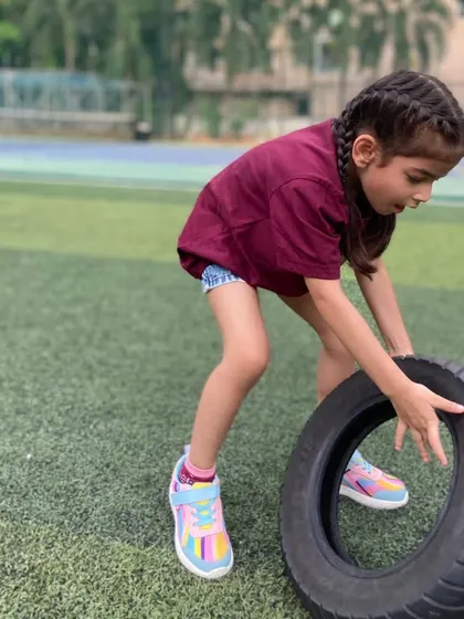Even our youngest guests get in on the action. A girl at a birthday party gets ready to flip a tire, showing that our activities are scalable and fun for all age groups.
