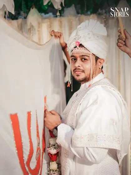 The groom awaits his bride during the Antarpat ceremony, a moment of sweet anticipation. We understand and capture the significance of each Maharashtrian wedding ritual.