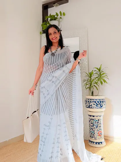 This white and black striped linen saree is a classic and versatile piece. It can be styled in many ways for a modern, minimalist look.
