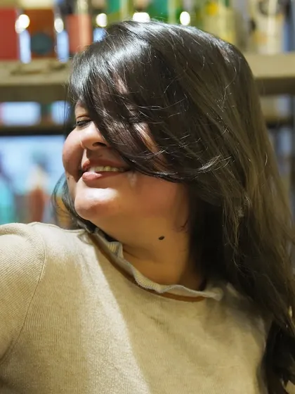 The smile that says it all. This happy client is enjoying her fresh new style, a testament to the transformative power of a great haircut and a little pampering.