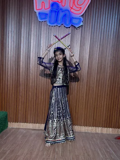Dressed in an elegant navy blue and gold outfit, this dancer is ready for her performance. We pay attention to every detail, from choreography to costume.