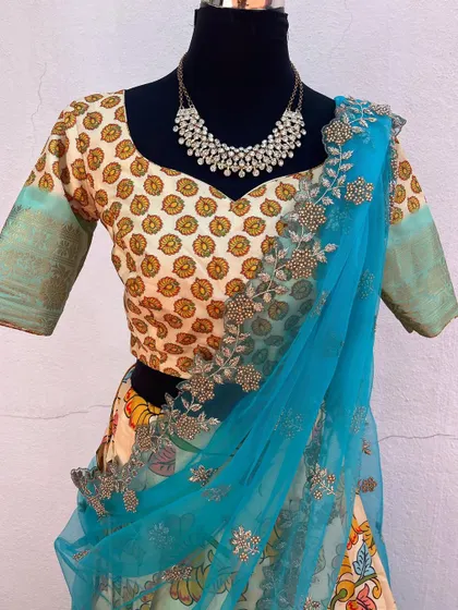 A Kalamkari print lehenga with a brocade blouse and a bright turquoise net dupatta.
