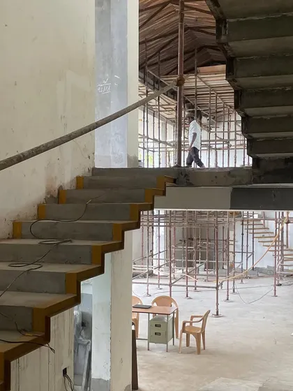 The interior of the hill house during construction, showing the multi-level spaces and the raw concrete structure.