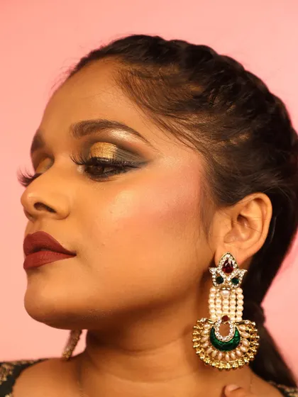 A dramatic Arabian-inspired makeup look. This style features a bold, golden cut-crease, heavy liner, and a deep red lip for a truly glamorous and exotic feel.