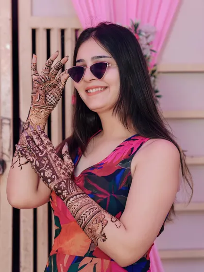 A close-up of a guest's smile and her intricate mehendi, capturing the festive spirit.