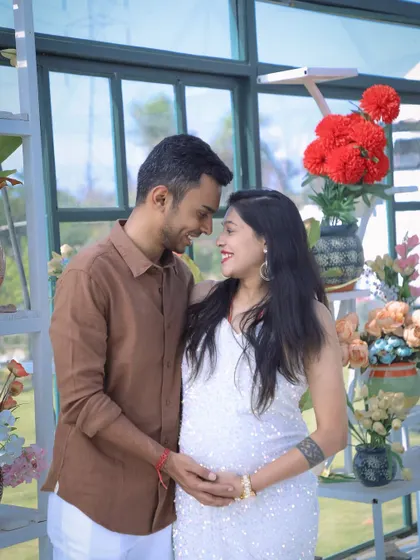 A sweet and intimate portrait of an expecting couple in a bright, airy setting. Their joyful expressions and close embrace perfectly capture the love and excitement of this special time.