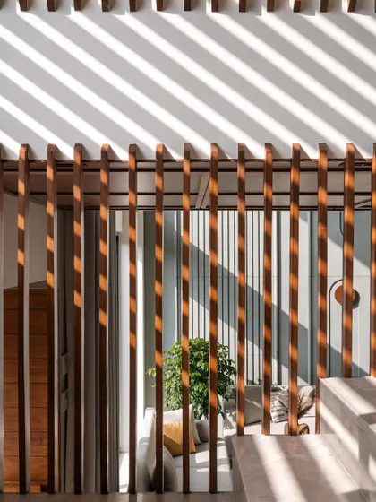**Amber House, Ahmedabad:** A close-up of the wooden screen shows how simple elements can create dynamic patterns. As light filters through, the shadows become a moving piece of art on the walls, constantly changing the feel of the space throughout the day.